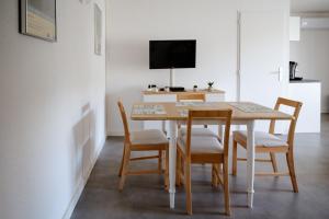einen Esstisch mit Stühlen und einen TV in der Unterkunft studio meublé vue exceptionnelle in Les Baux-de-Provence