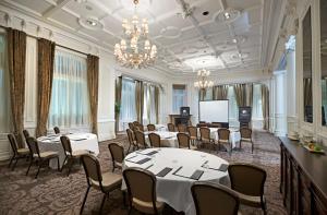 a conference room with tables and chairs and a screen at DoubleTree by Hilton Hotel & Spa Liverpool in Liverpool