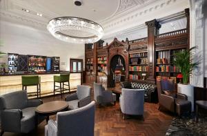 a library with chairs and tables and a chandelier at DoubleTree by Hilton Hotel & Spa Liverpool in Liverpool