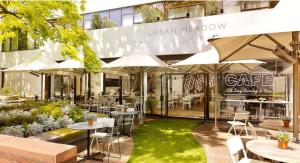 an outdoor restaurant with tables and chairs and umbrellas at DoubleTree by Hilton London - Hyde Park in London