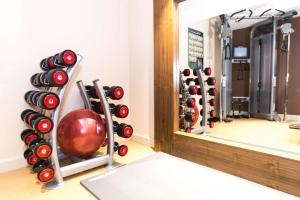een fitnessruimte met halters en een spiegel bij DoubleTree by Hilton London - Hyde Park in Londen