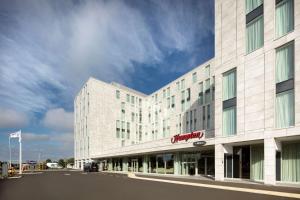 a large white building with a sign on it at Hampton By Hilton London Stansted Airport in Stansted Mountfitchet