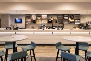 a restaurant with two tables and chairs and a bar at Hampton By Hilton London Stansted Airport in Stansted Mountfitchet