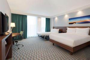 um quarto de hotel com duas camas e uma televisão de ecrã plano em Hampton By Hilton London Stansted Airport em Stansted Mountfitchet