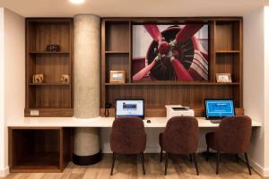 a desk with two laptops on it in a room at Hampton By Hilton London Stansted Airport in Stansted Mountfitchet +19 photos