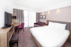 um quarto de hotel com uma cama e uma televisão em Hampton By Hilton Blackpool em Blackpool