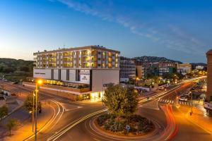 a city with a building and a street at night at Apartaments Condado by Marsol in Lloret de Mar