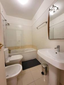 a white bathroom with a sink and a toilet at Lisbon Family Residence in Lisbon