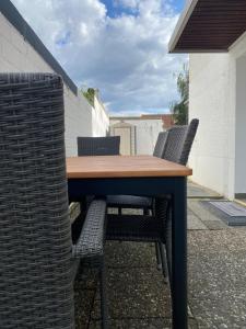 einen Holztisch und Stühle auf einer Terrasse in der Unterkunft Lux Apartment near Frankfurt! in Mörfelden-Walldorf