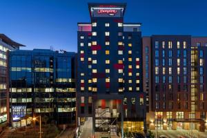 a tall building with a sign on the top of it at Hampton by Hilton London Croydon in Croydon