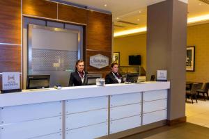 twee vrouwen aan een balie in een hotellobby bij Hampton by Hilton London Croydon in Croydon