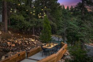 d'une terrasse avec une table et des chaises dans les bois. dans l'établissement The Mod Lodge - Lake Arrowhead, à Lake Arrowhead