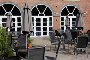 an outdoor patio with tables and chairs and umbrellas at DoubleTree by Hilton York in York