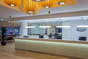 an office lobby with a reception desk and a large mirror at Hampton by Hilton London Gatwick Airport in Horley