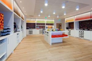 a large kitchen with white cabinets and wooden floors at Hampton by Hilton London Gatwick Airport in Horley