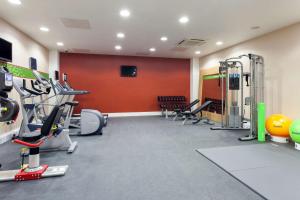 a gym with several treadmills and exercise equipment at Hampton by Hilton London Gatwick Airport in Horley
