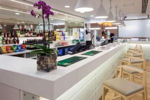a bar in a pharmacy with a flower on the counter at Hampton by Hilton London Gatwick Airport in Horley