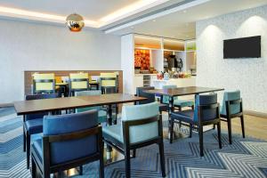 a dining room with tables and chairs and a kitchen at Hampton by Hilton Glasgow Central in Glasgow