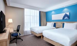 a hotel room with two beds and a tv at Hampton by Hilton Glasgow Central in Glasgow