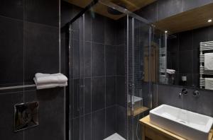 Baño negro con lavabo y ducha en Studio Forclaz Avec Coin Nuit, en Le Grand-Bornand