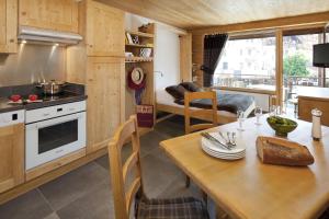 a kitchen and dining room with a table and a dining room at Studio Forclaz Avec Coin Nuit in Le Grand-Bornand