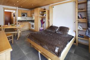 1 dormitorio con 1 cama grande y cocina en Studio Forclaz Avec Coin Nuit, en Le Grand-Bornand