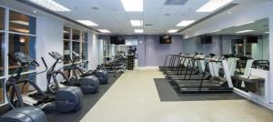 a gym with a row of treadms and cardio machines at DoubleTree by Hilton Dartford Bridge in Dartford