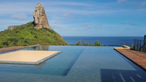 a infinity pool with a view of a mountain at Hamares Boutique Hotel in Fernando de Noronha