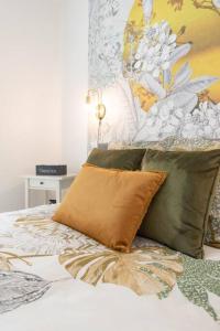 uma cama com quatro almofadas em cima em Parisian & Chic Appartement -15 min from Paris Center em Ivry-sur-Seine