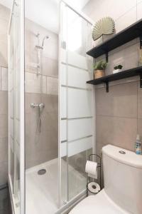 uma casa de banho com um chuveiro e um WC branco em Parisian & Chic Appartement -15 min from Paris Center em Ivry-sur-Seine