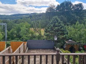 a wooden deck with a view of a mountain at Bob's Bunkhouse in Troed-y-rhiw