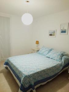 a bedroom with a bed with a blue comforter at Rabastens in Mar de las Pampas +24 photos