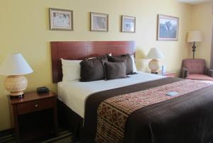 a hotel room with a large bed and a chair at Moenkopi Legacy Inn & Suites in Tuba City
