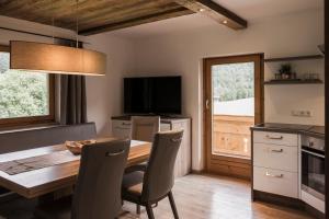 a dining room with a table and chairs and a television at Chalet Gasteig in Oberau