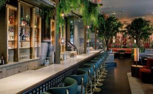 a bar in a restaurant with blue chairs at The Trafalgar St. James, London Curio collection by Hilton in London