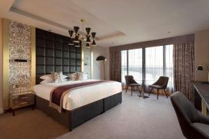 - une chambre avec un grand lit, un bureau et des chaises dans l'établissement DoubleTree by Hilton Edinburgh - Queensferry Crossing, à North Queensferry