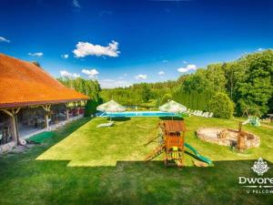 a backyard with a pool and a playground at Agroturystyka "Dworek u Pelców" in Ryn