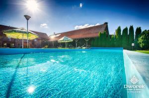 a large swimming pool in front of a house at Agroturystyka "Dworek u Pelców" in Ryn +12 photos
