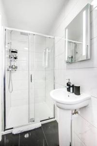 a white bathroom with a shower and a sink at SCA - Luxurious Studio - VS5 in Wolverhampton