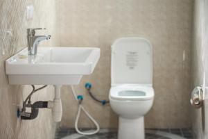 a bathroom with a sink and a toilet at Cambria Hotel in Nosy Be