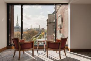 Cette chambre dispose d'une grande fenêtre et d'une table avec des chaises. dans l'établissement Hilton The Hague, à La Haye