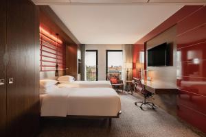Cette chambre comprend deux lits et une télévision. dans l'établissement Hilton The Hague, à La Haye