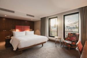 une chambre d'hôtel avec un lit, une chaise et une fenêtre dans l'établissement Hilton The Hague, à La Haye