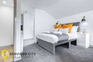 een slaapkamer met een groot bed met oranje kussens bij SCA - Perfect City Studio - VS7 in Wolverhampton
