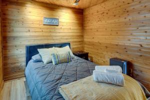 1 dormitorio con 1 cama en una pared de madera en Okauchee Lake Vacation Rental with Boat Dock! en Oconomowoc