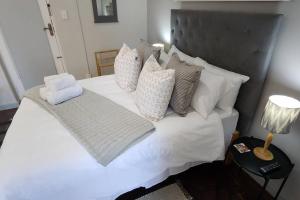 ein Schlafzimmer mit einem weißen Bett mit Kissen in der Unterkunft Ebenezer in Somerset West