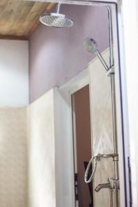 a bathroom with a shower with a mirror at Cambria Hotel in Nosy Be