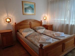 1 dormitorio con cama de madera y toallas en Apartment "Relax" - Wilson's Promenade en Sarajevo