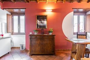 una cucina con pareti rosse e un mobile in legno di Manilio Ghetto Ancient Rome a Roma Altre 27 foto