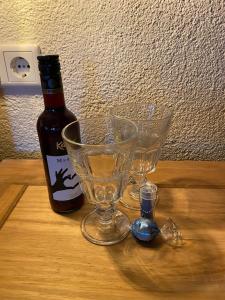 Una botella de vino y dos copas en una mesa. en Alpenranch, 